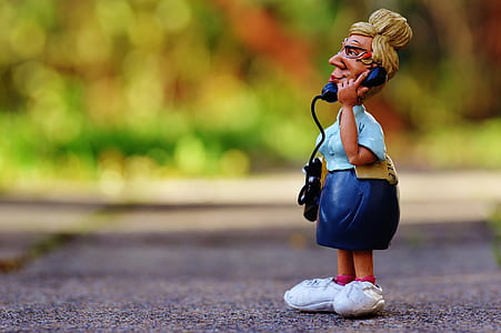 brown haired woman figurine calling on telephone in selective focus photography thumbnail