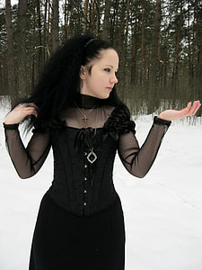 woman wearing black long-sleeved dress at forest surrounded with snow thumbnail