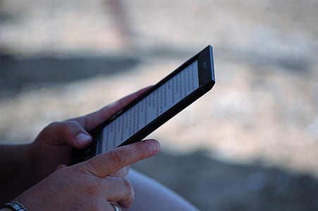 selective focus photography of person using E-book reader thumbnail