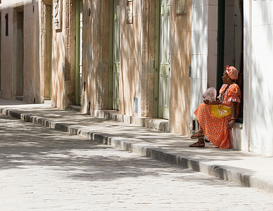 woman wearing red dress sitting on gray concrete wall thumbnail