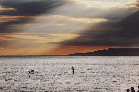 man standing on surfboard on body of water thumbnail