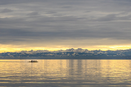 people riding boat at the ocean near island during day thumbnail