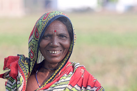 selective focus photography of woman in red and green tribal top smiling thumbnail