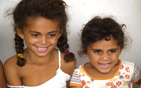 two smiling girl standing side-by-side thumbnail