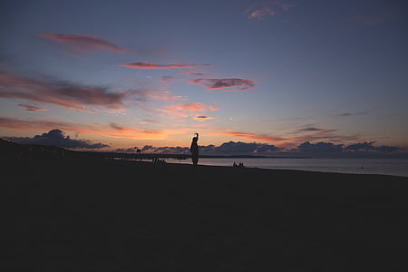 silhouette of person standing on beach thumbnail