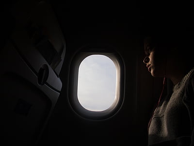 person sitting inside aircraft near window thumbnail