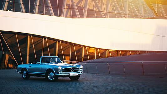 landscape photography of classic gray Mercedes-Benz convertible coupe near white commercial building during daytime thumbnail
