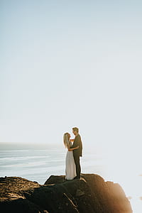 man and woman standing on brown rock during daytime thumbnail
