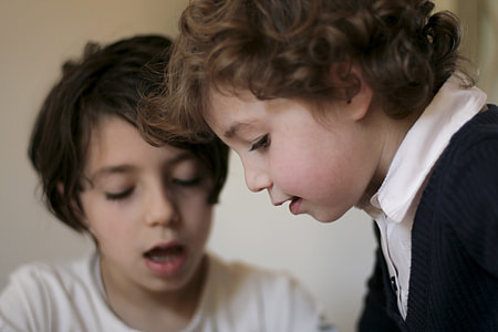 boy in beige crew-neck top with mouth open beside boy wearing black and white collared shirt thumbnail
