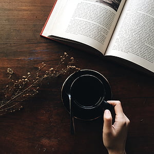person holding black coffee mug with saucer thumbnail