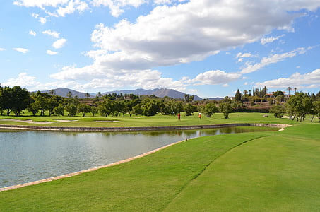 man-made lake surrounded by lawn grass taken at daytime thumbnail