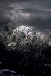 aerial photography of mountain under cloudy sky thumbnail