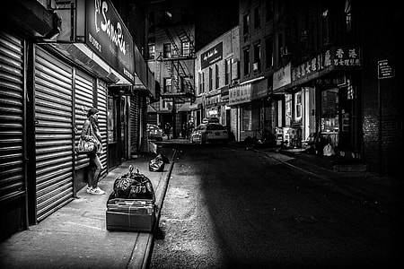 grayscale photo of woman leaning on door shutter thumbnail