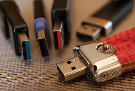 selective focus photography of assorted-color flash drives on leather thumbnail