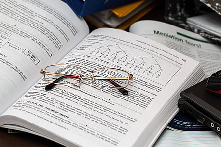 gold-colored framed eyeglasses on top of book thumbnail