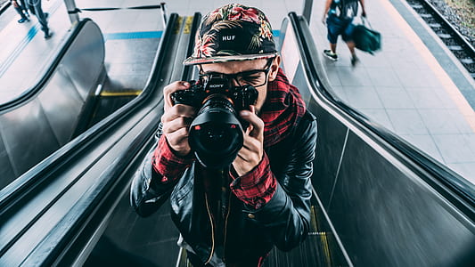 Man Wearing Black Leather Zip Up Jacket and Dslr Camera thumbnail