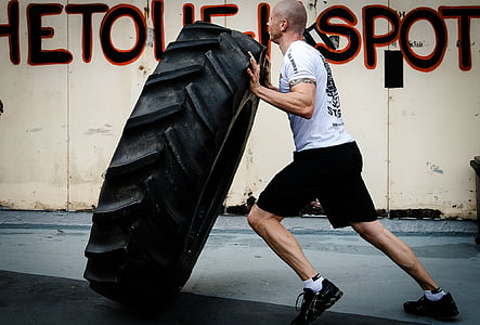 man carrying vehicle tire thumbnail