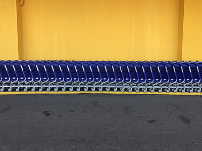 blue shopping cart on yellow concrete flooring thumbnail