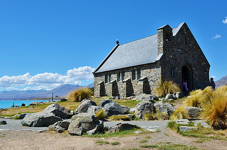 gray concrete house on grass field near body of water thumbnail