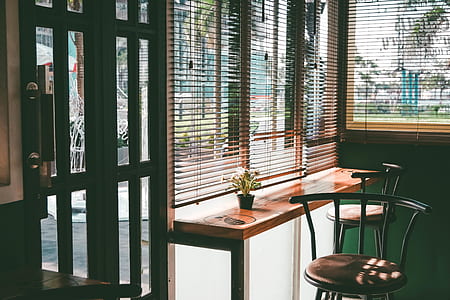 two brown padded bar stools near end table and window blinds thumbnail