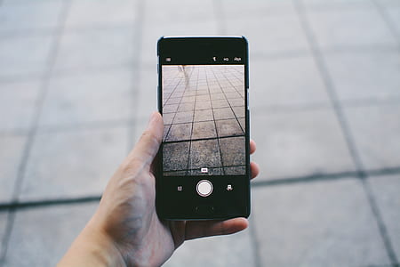 person holding Android smartphone taking picture the concrete pavement thumbnail
