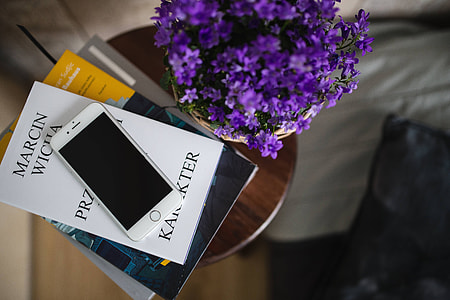Books and purple flowers on a wooden stool by the bed thumbnail
