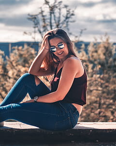 Woman Wearing Red Camisole and Blue Denim Jeans Outdoors thumbnail