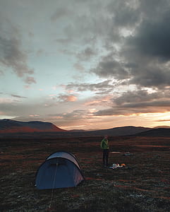 person standing near blue dome tent during daytime thumbnail