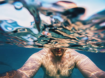 man swimming during daytime thumbnail
