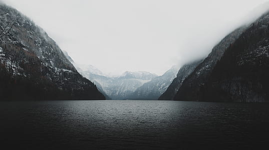 photography of body of water between mountain thumbnail
