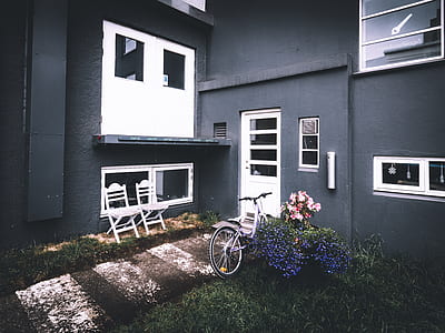 white bicycle parked in front of door thumbnail