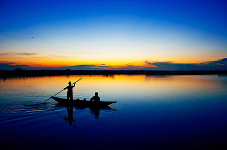 silhouette photography of two people on boat thumbnail