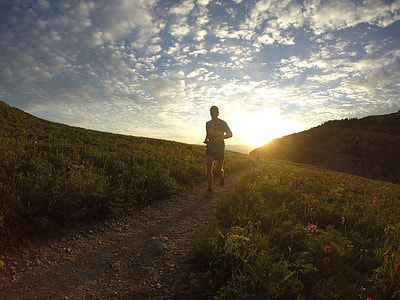 man running on pathway between grass thumbnail