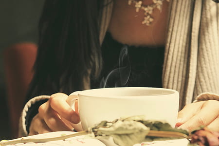 woman holding white ceramic coffee mug thumbnail