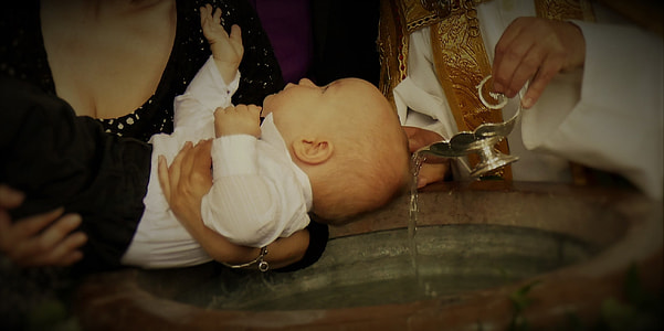 person carrying infant with a priest baptizing baby on baptismal font thumbnail