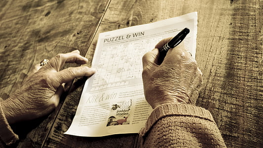 person solving crossword puzzle thumbnail