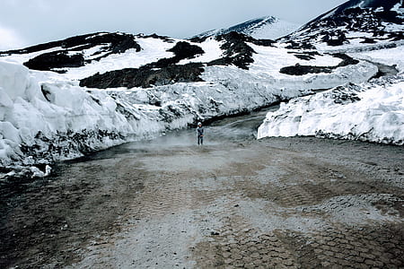 boy standing in the middle of the road during winter and day thumbnail