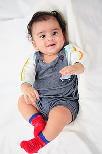 toddler lying on bed smiling thumbnail
