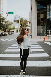woman in gray sweater and black pants on pedestrian crossing during daytime thumbnail