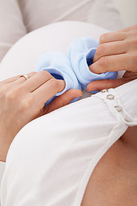 woman holding pair of baby's blue socks thumbnail