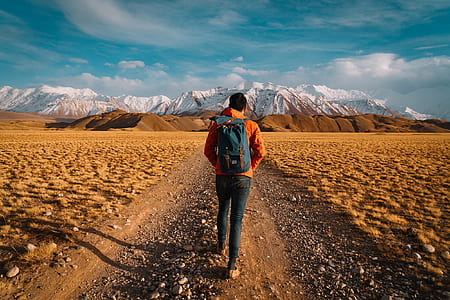 man walking nearby mountains thumbnail