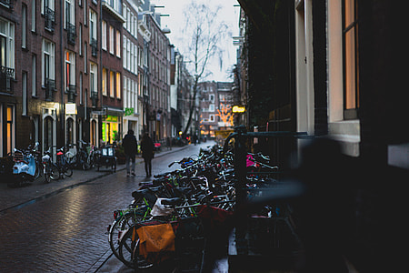 two person walking on road between building thumbnail