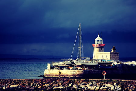 lighthouse surrounded by boats thumbnail