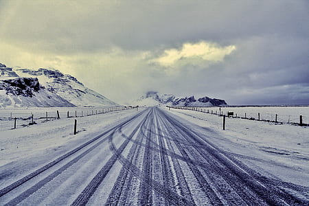snowcovered road under cloudy sky thumbnail