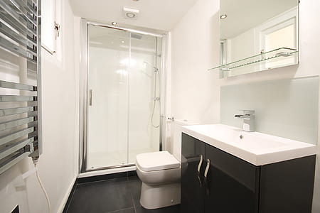 white ceramic toilet bowl near black and white vanity combo thumbnail