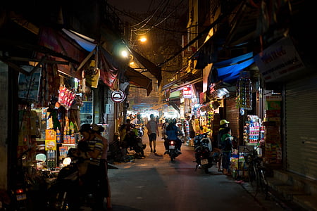 people on road beside buildings with vehicles during night time thumbnail