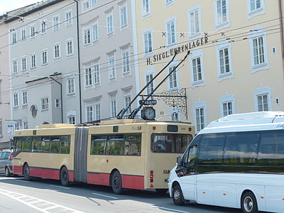 beige and red bus near beige painted building thumbnail