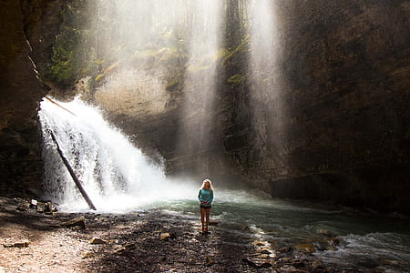 woman standing near waterfalls during daytime thumbnail