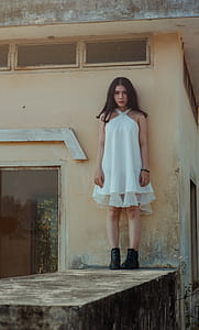 Woman in White Dress Standing on Concrete Wall thumbnail