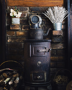 cast iron wood burner stove beside pile of firewood thumbnail